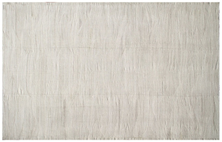 Large earth-tone flatweave Ariana kilim rug in natural undyed organic wool with subtle woven texture.