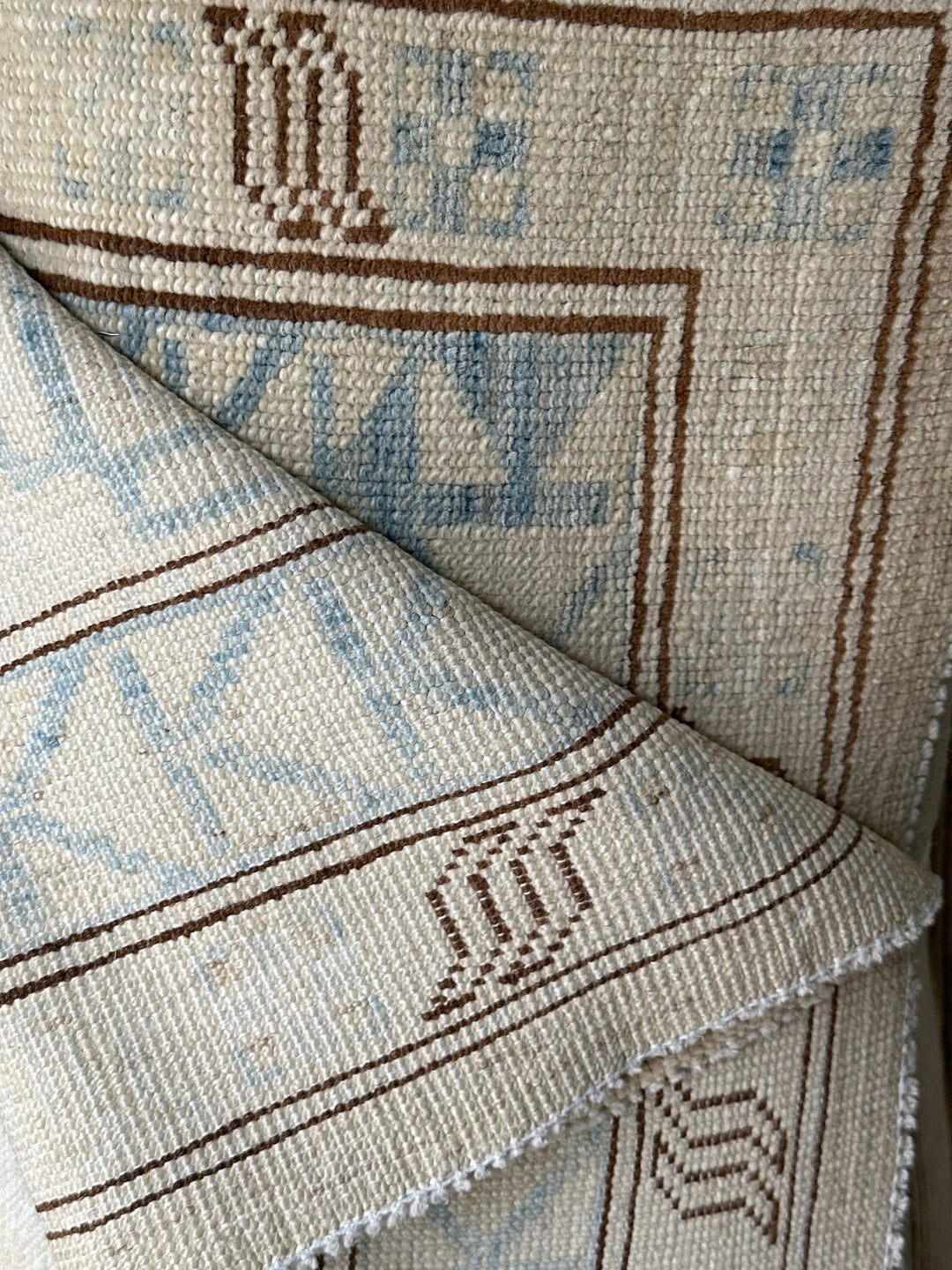 Ariana large Caucasian design wool rug in ivory and pale blue, hand-knotted in Afghanistan by Hazara artisans. Luxury oversized geometric area rug for elegant interiors.