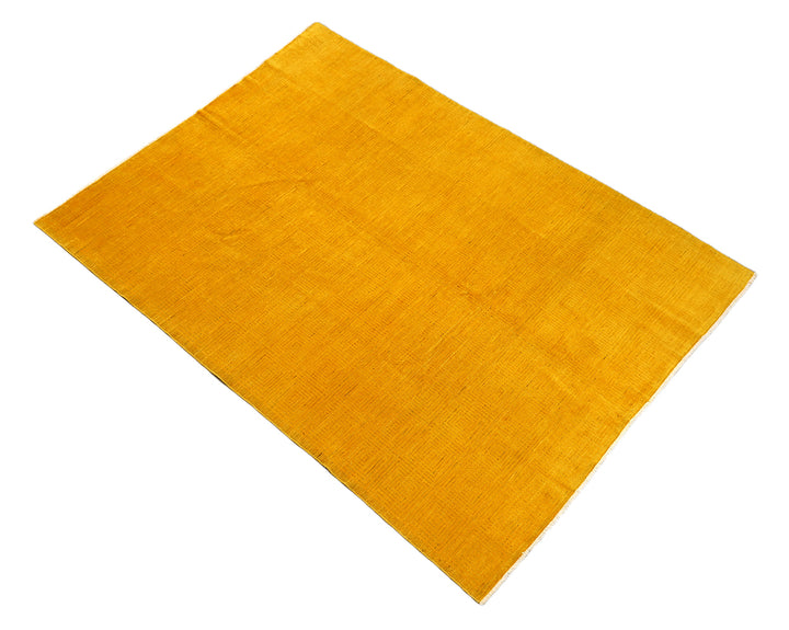 7'x9'9" hand-knotted yellow geometric Ariana overdyed wool rug featuring subtle artisan details and vibrant yellow tones