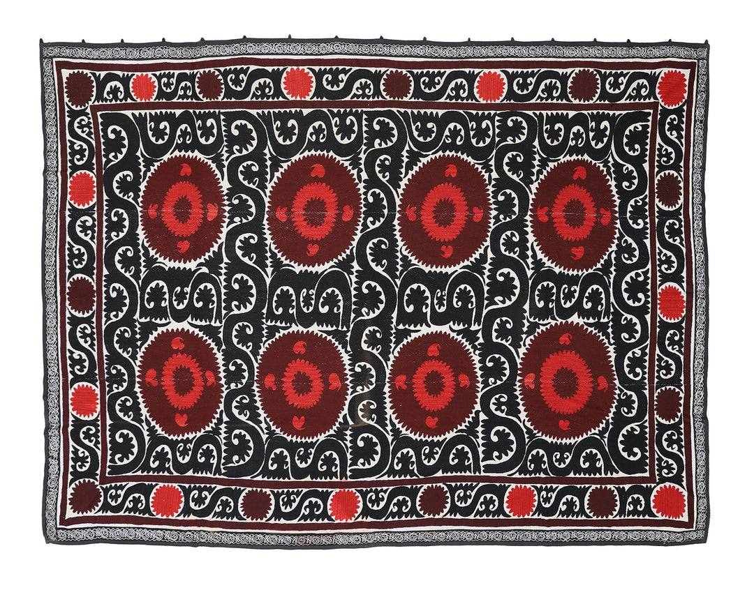 Decorative rug with red and brown patterns on a black background