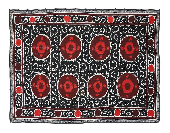 Decorative rug with red and brown patterns on a black background