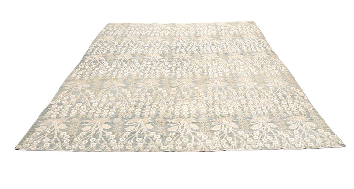 Ariana Transitional 8x11 hand-knotted Afghan wool rug featuring a directional blue millfleur tree design with stark white cotton floral accents.