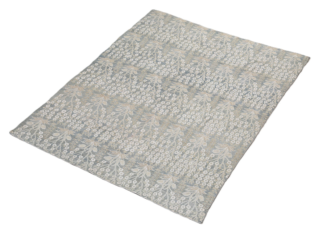 Ariana Transitional 8x11 hand-knotted Afghan wool rug featuring a directional blue millfleur tree design with stark white cotton floral accents.