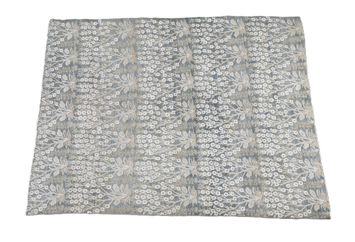Ariana Transitional 8x11 hand-knotted Afghan wool rug featuring a directional blue millfleur tree design with stark white cotton floral accents.