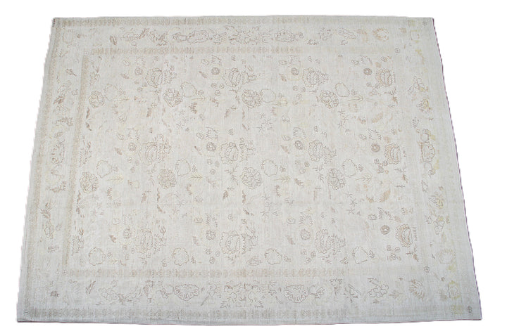 An off-white rectangular area rug with a faded beige floral and vine pattern, shown flat against a white background.