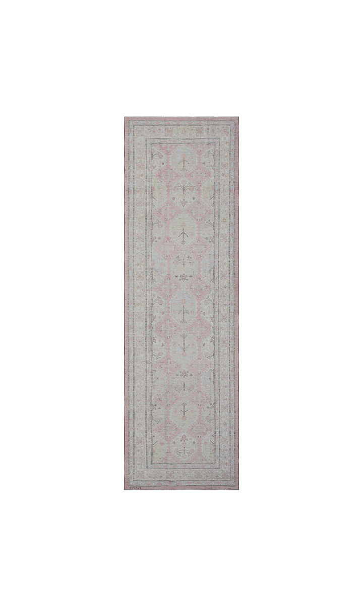 Authentic hand-knotted Afghan runner rug from the Ariana Hazara Collection, featuring geometric Caucasian motifs in pink, ivory, and blue organic wool.