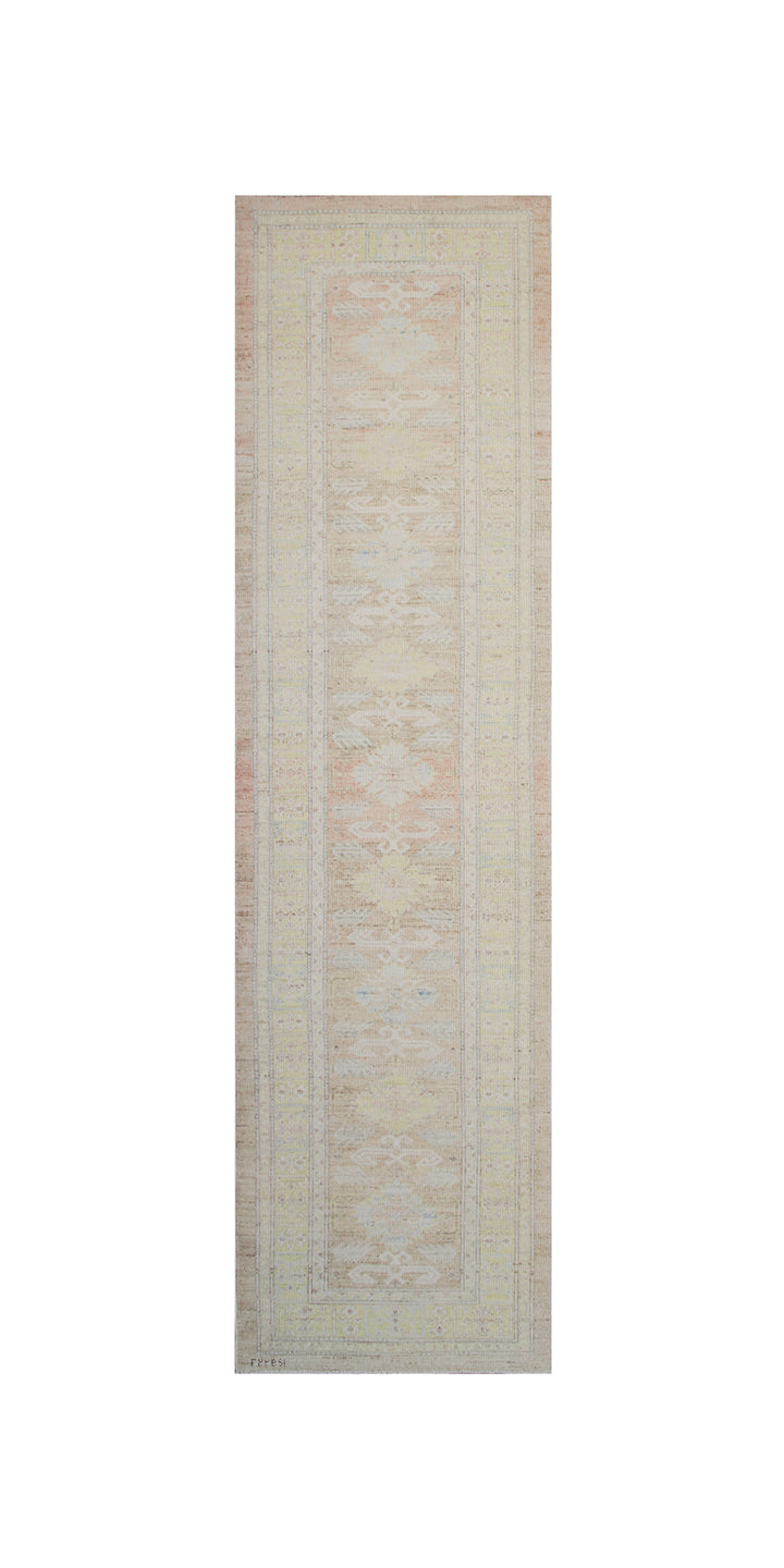Authentic hand-knotted Afghan hallway runner rug from the Ariana Hazara Collection, featuring traditional geometric tribal motifs in soft pink organic wool.
