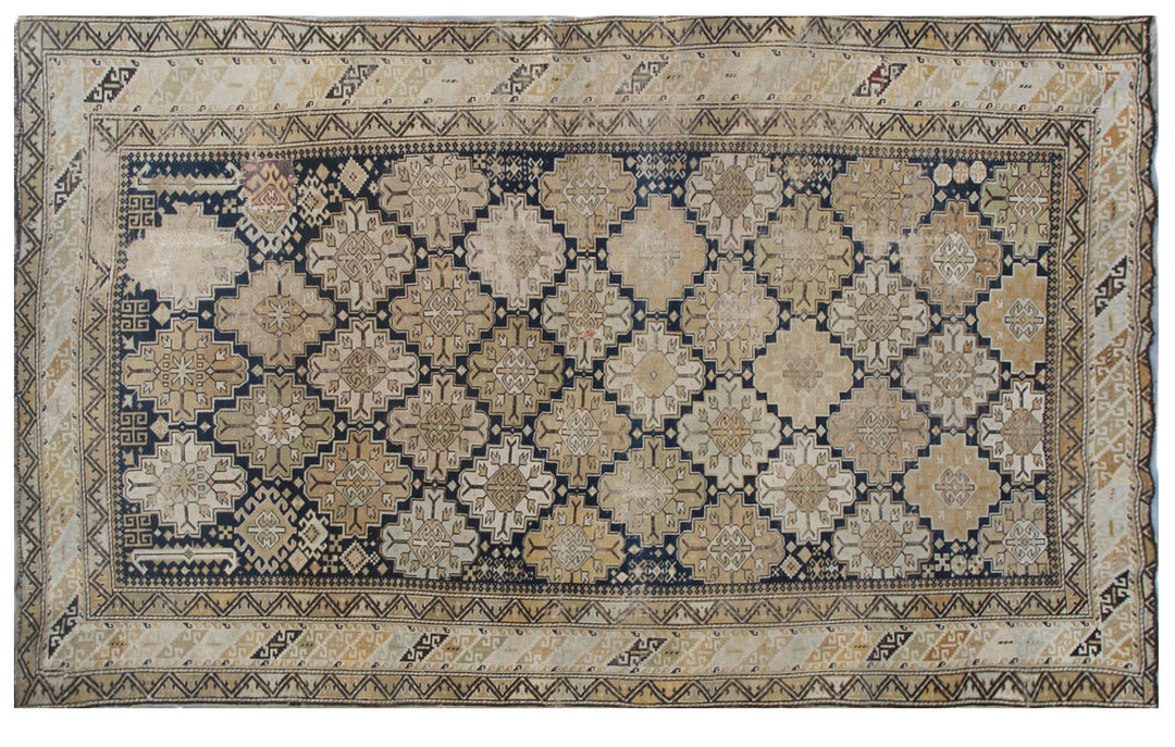 Distressed antique Caucasian Shirvan wool rug featuring geometric motifs in navy blue and tan with heavy distress and authentic age patina