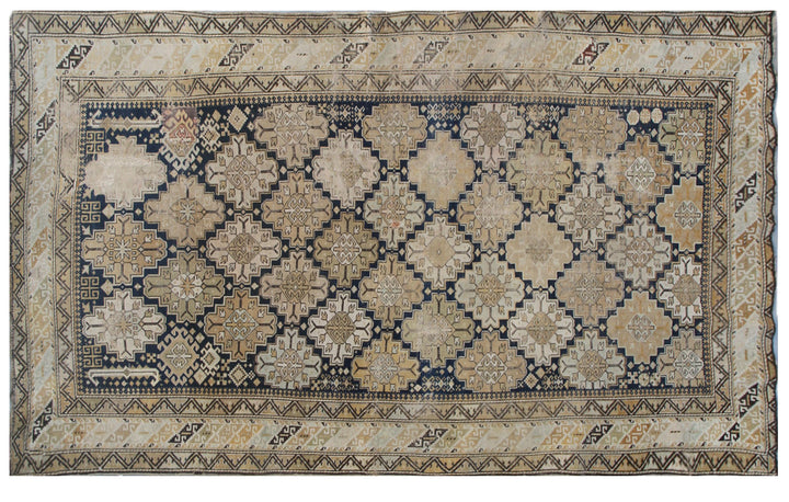 Distressed antique Caucasian Shirvan wool rug featuring geometric motifs in navy blue and tan with heavy distress and authentic age patina