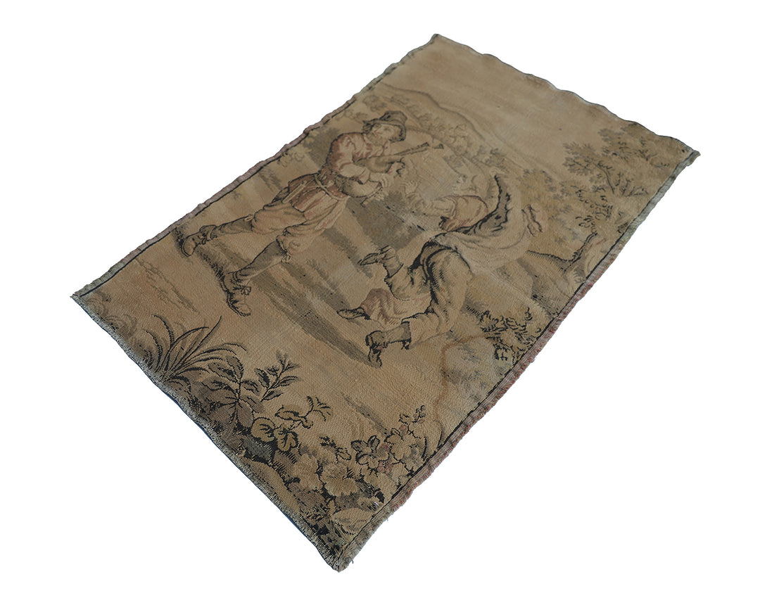 Early 20th-century French power-loomed tapestry depicting a man playing a pipe instrument and a man dancing in a pastoral setting, measuring 3 feet by 4 feet