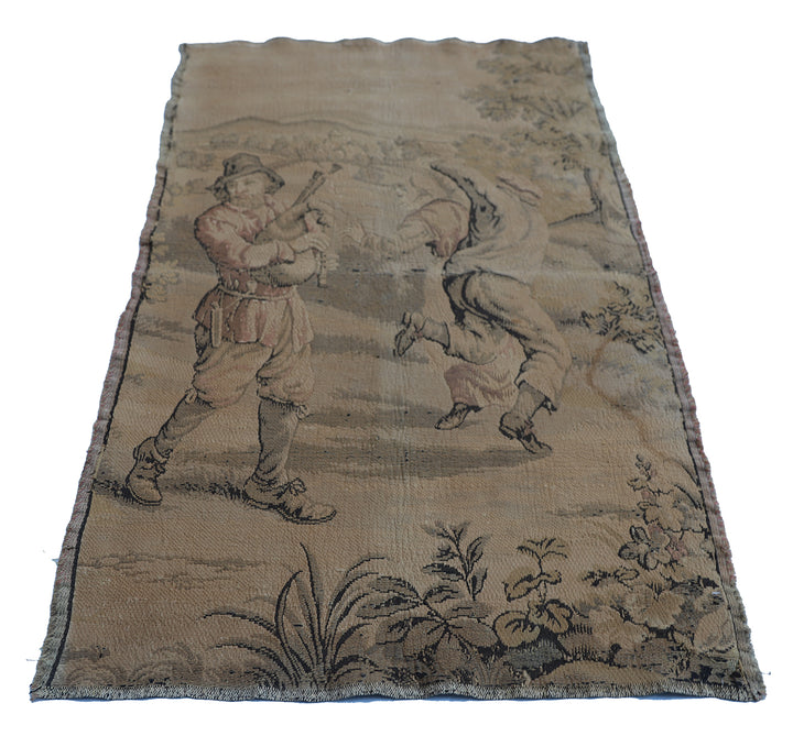 Early 20th-century French power-loomed tapestry depicting a man playing a pipe instrument and a man dancing in a pastoral setting, measuring 3 feet by 4 feet
