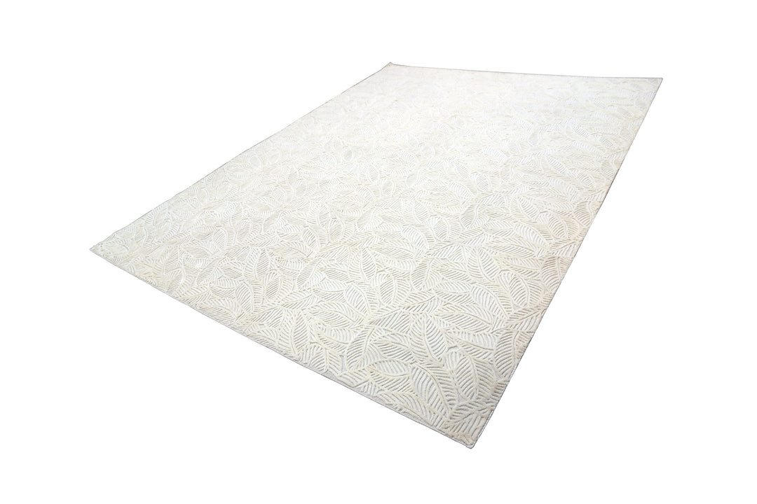 White hand-loomed New Zealand wool area rug with over-tufted floral textured design.