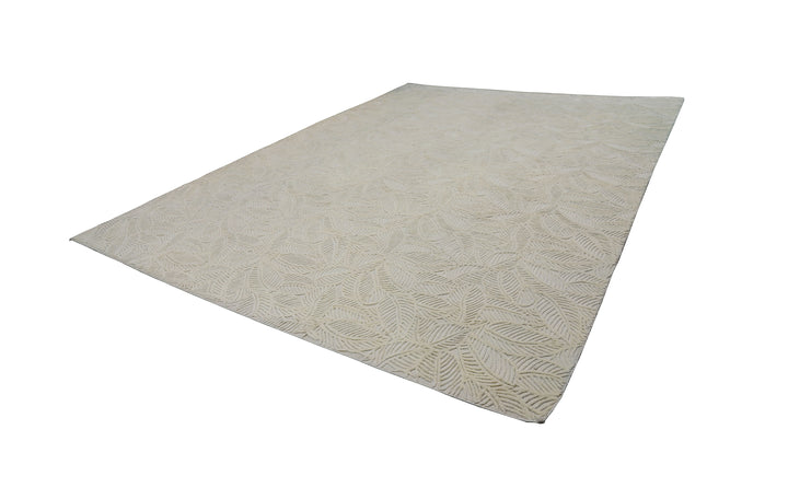 White hand-loomed New Zealand wool area rug with over-tufted floral textured design.