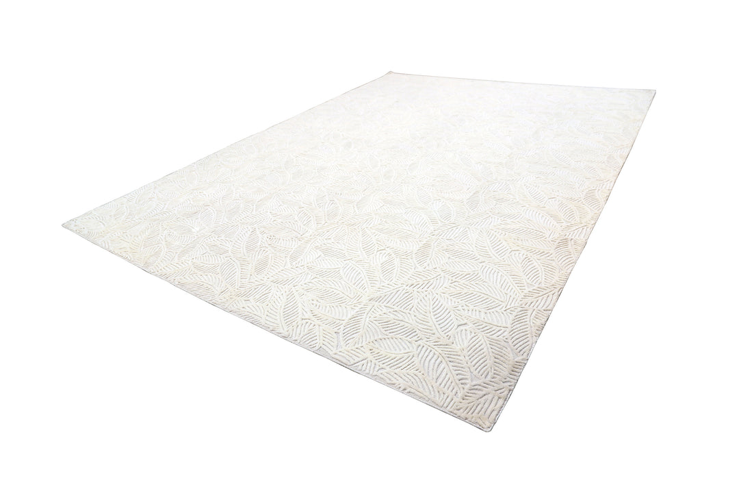 White hand-loomed New Zealand wool area rug with over-tufted floral textured design.