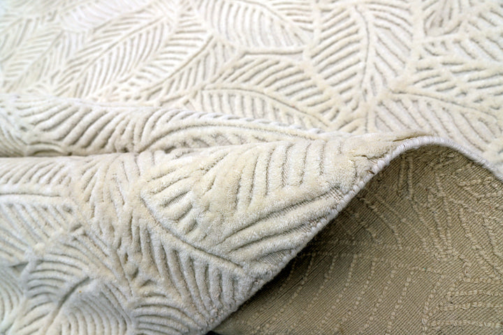 White hand-loomed New Zealand wool area rug with over-tufted floral textured design.