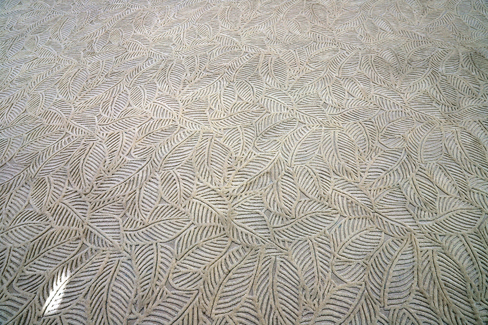 White hand-loomed New Zealand wool area rug with over-tufted floral textured design.