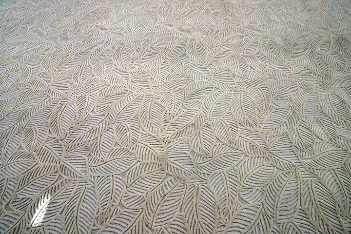White hand-loomed New Zealand wool area rug with over-tufted floral textured design.