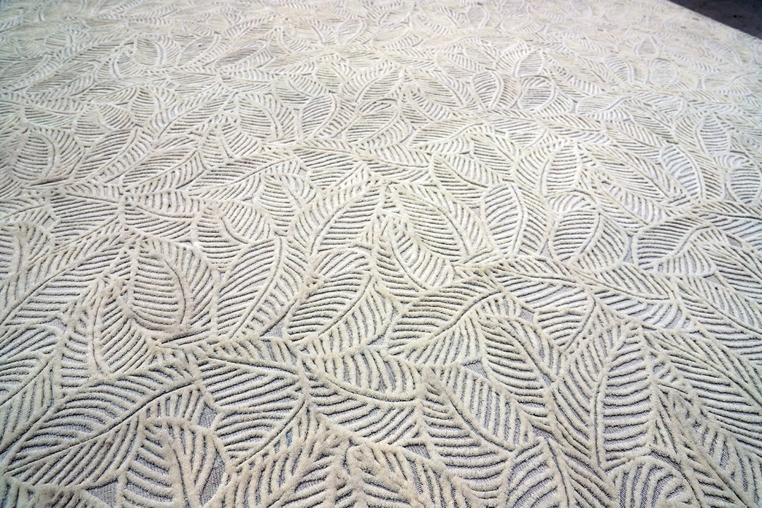 White hand-loomed New Zealand wool area rug with over-tufted floral textured design.