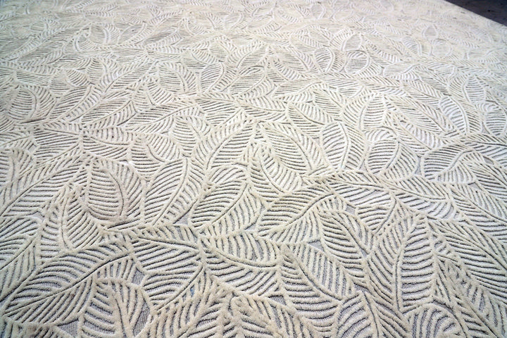 White hand-loomed New Zealand wool area rug with over-tufted floral textured design.