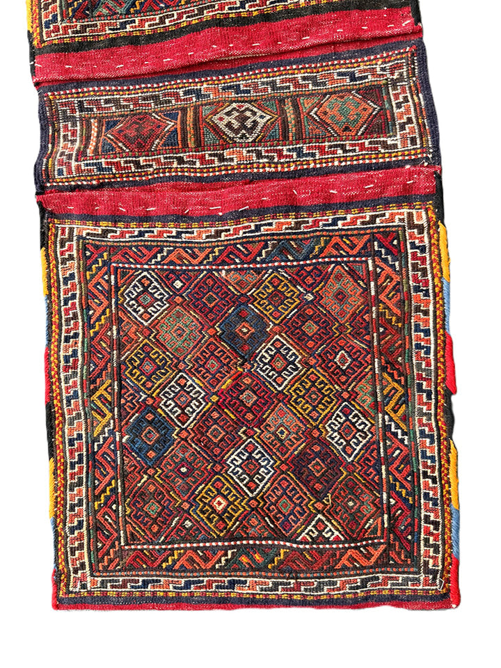Handwoven Persian tribal storage saddle bag with geometric patterns in wool.