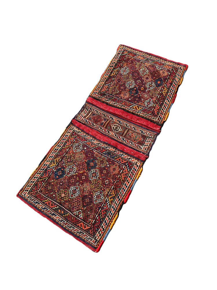 Handwoven Persian tribal storage saddle bag with geometric patterns in wool.