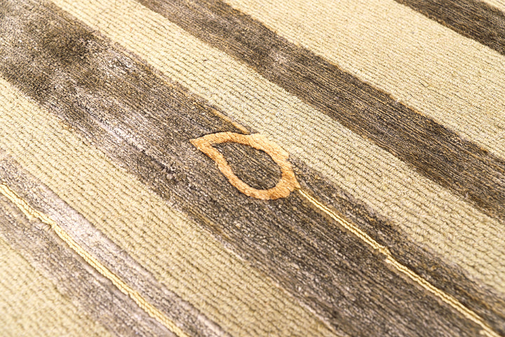 Hand-knotted Modern Tibetan Ariana rug in wool and silk featuring a geometric pattern in gold and greenish hues