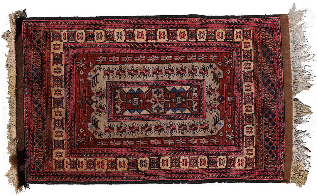 A multicolored, hand-knotted silk and wool rug with a geometric pattern and fringed edges.