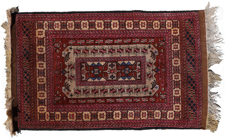 A multicolored, hand-knotted silk and wool rug with a geometric pattern and fringed edges.