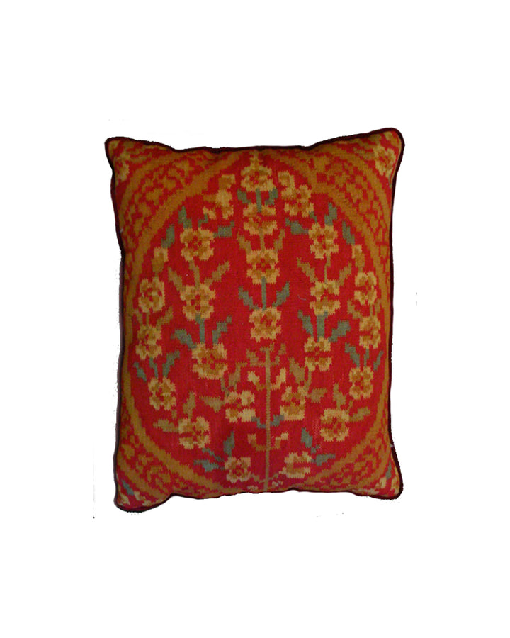 Close-up of a red and green handwoven wool kilim pillowcase with yellow Ottoman geometric patterns.
