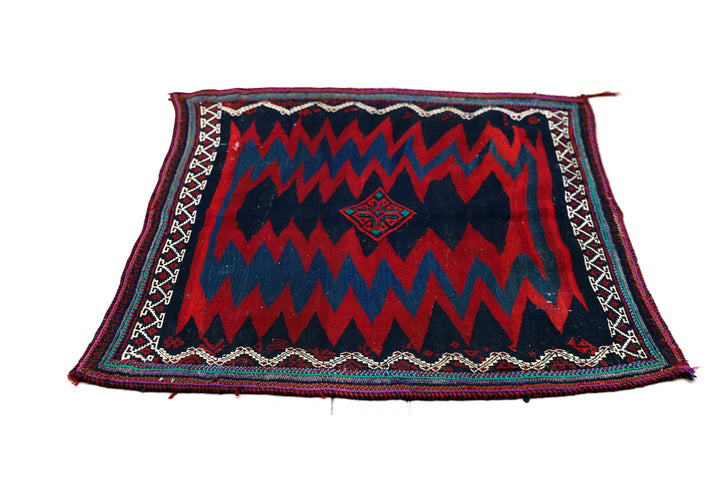 Authentic 4'x4' square Persian Rukursi Sofreh Kilim tribal rug with a hand-woven wool chevron pattern and textured flatweave pile details.