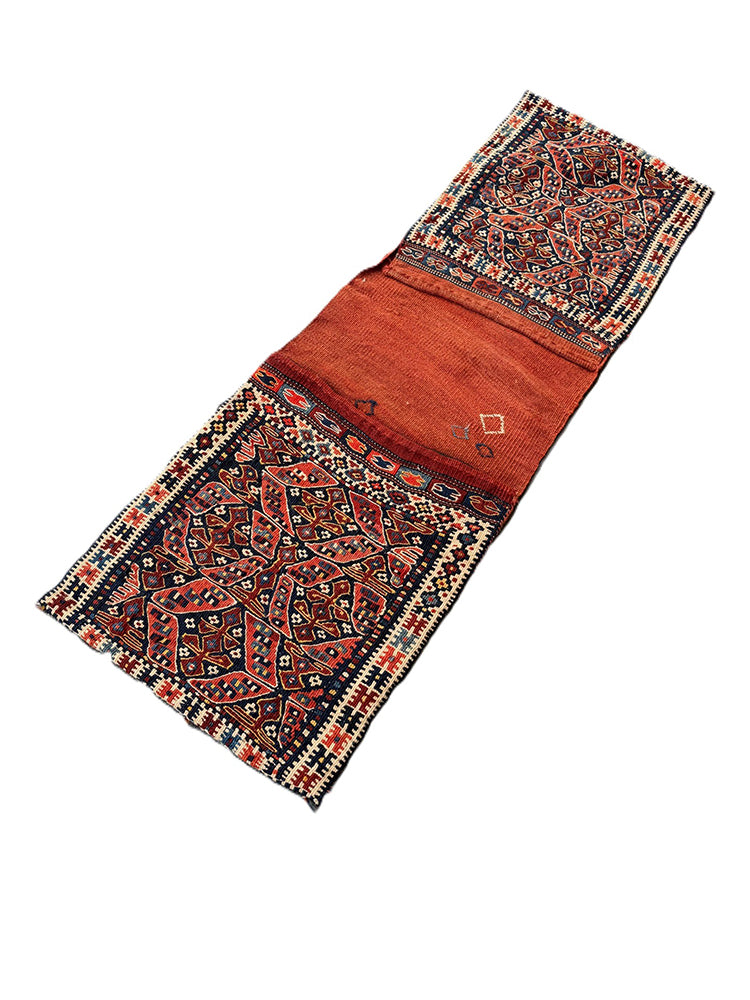 Long vintage Shahsavan Persian tribal saddle bag with terracotta and navy geometric patterns.