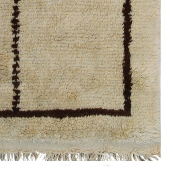 A small 3x5 vintage Turkish Tulu rug with a shaggy ivory wool pile and a minimalist brown tribal geometric design.