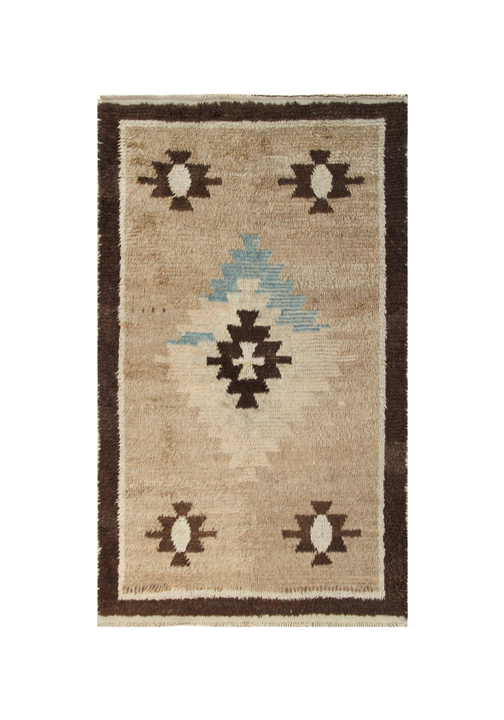 A 4x7 vintage Turkish Tulu rug featuring a shaggy brown wool pile with a central blue/brown medallion and four corner motifs.