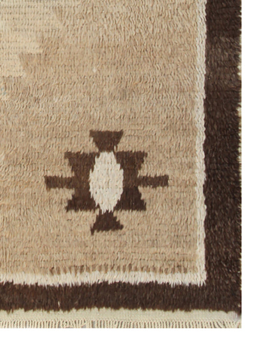 A 4x7 vintage Turkish Tulu rug featuring a shaggy brown wool pile with a central blue/brown medallion and four corner motifs.