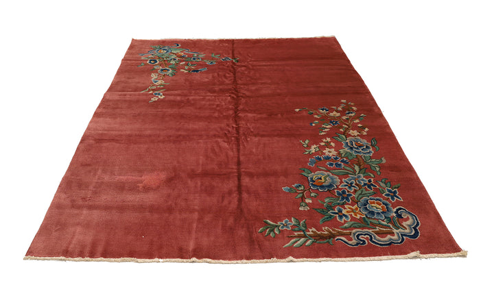 A 9x11 vintage Chinese Art Deco wool rug with a soft salmon pink background and sage green floral accents in the corners.