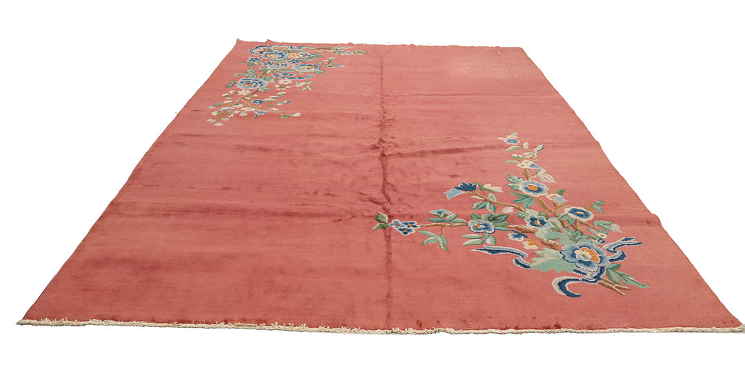 A 9x11 vintage Chinese Art Deco wool rug with a soft salmon pink background and sage green floral accents in the corners.