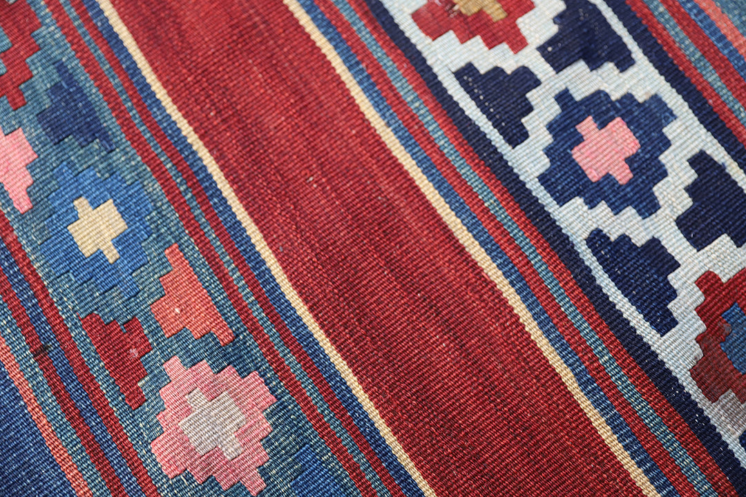 Vintage Caucasian flat-weave kilim rug with colorful vegetable-dyed geometric stripes and diamond motifs in terracotta red, green, and brown