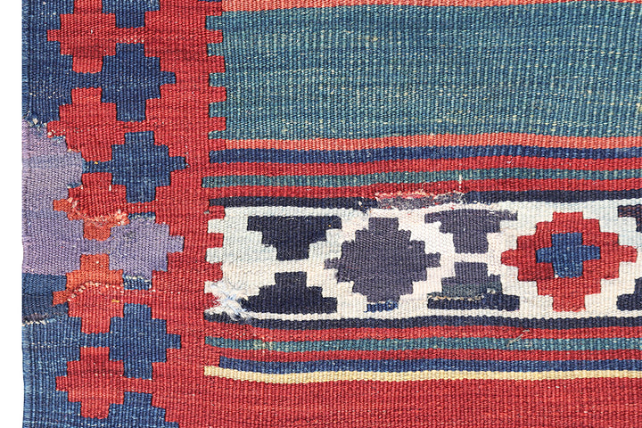 Vintage Caucasian flat-weave kilim rug with colorful vegetable-dyed geometric stripes and diamond motifs in terracotta red, green, and brown