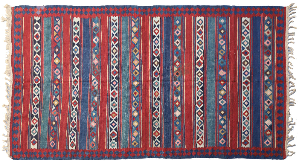 Vintage Caucasian flat-weave kilim rug with colorful vegetable-dyed geometric stripes and diamond motifs in terracotta red, green, and brown