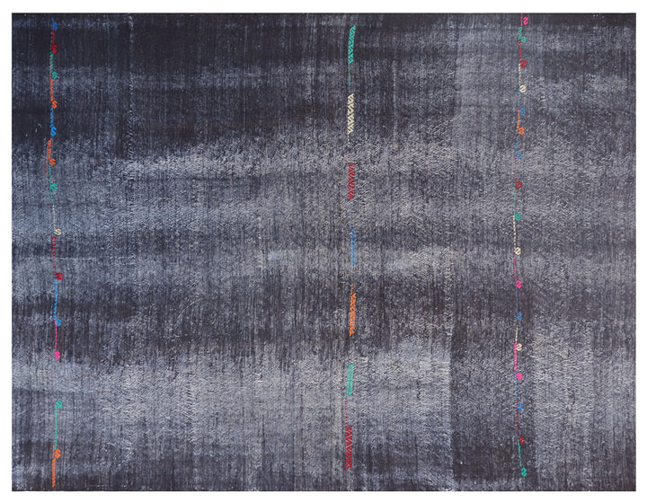 An abstract square textile or rug with a distressed charcoal gray and black background, featuring vertical rows of small colorful embroidered or printed accents in red, orange, teal, pink, and white.