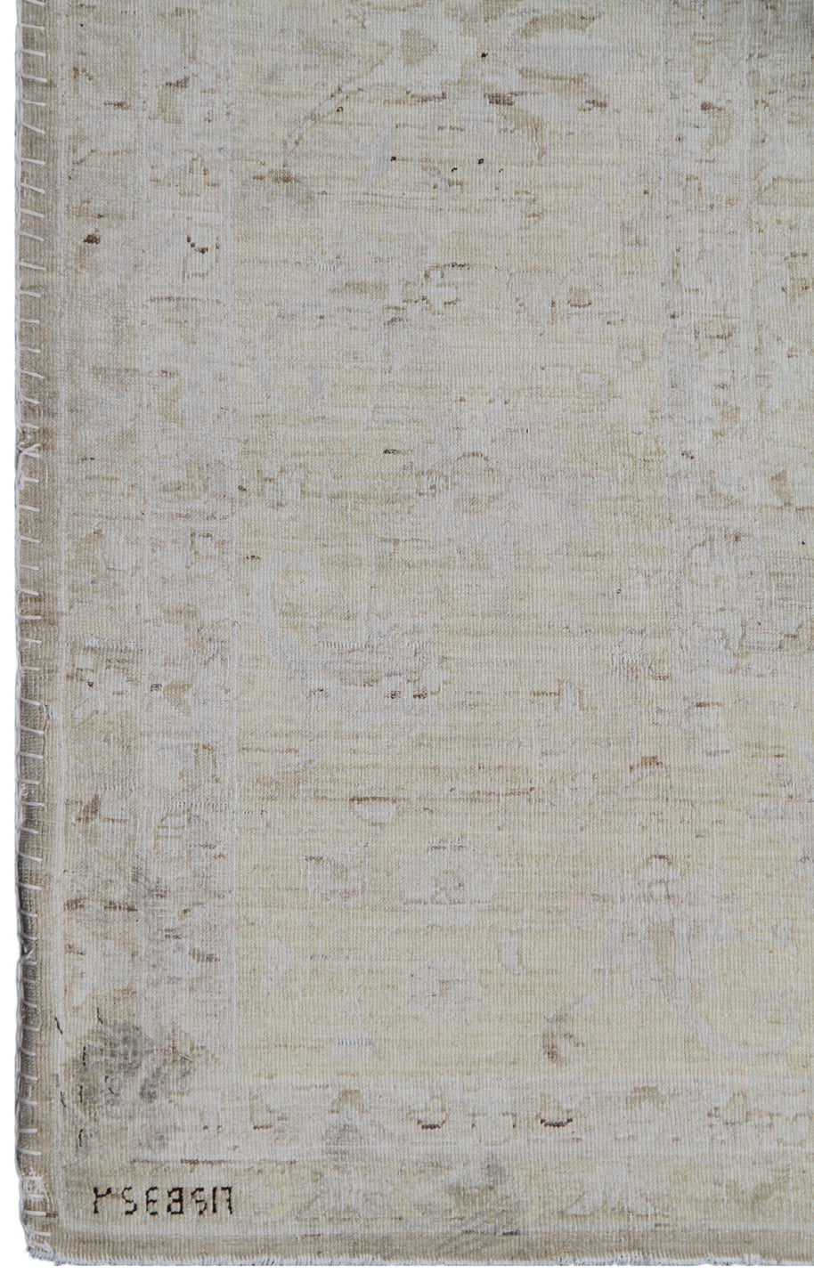 Textured beige rug with a signature at the bottom right corner