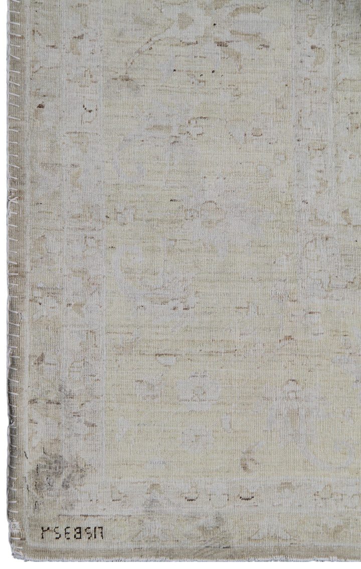 Textured beige rug with a signature at the bottom right corner