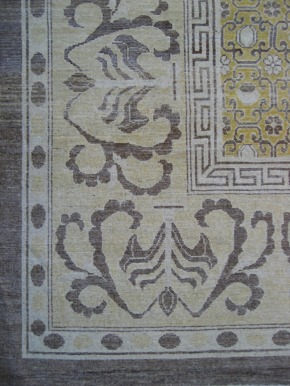Close-up of a patterned fabric with intricate designs on a beige background