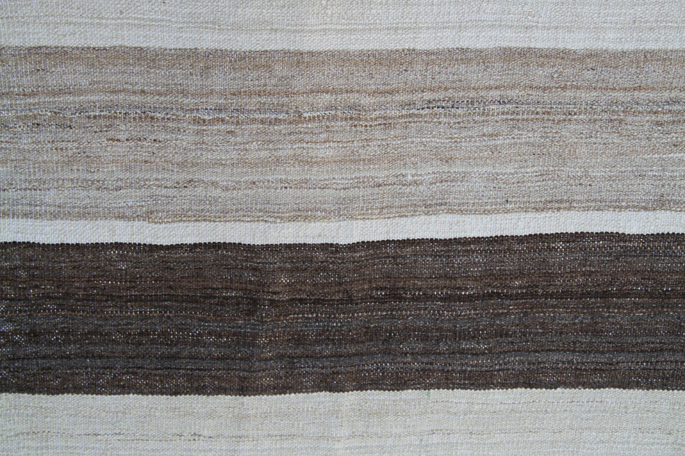 Organic modern sitting area styled with a 6x10 earth tone cream and brown striped Afghan wool kilim from Ariana Rugs West Hollywood.