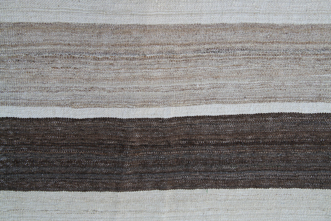 Organic modern sitting area styled with a 6x10 earth tone cream and brown striped Afghan wool kilim from Ariana Rugs West Hollywood.