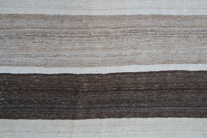 Organic modern sitting area styled with a 6x10 earth tone cream and brown striped Afghan wool kilim from Ariana Rugs West Hollywood.