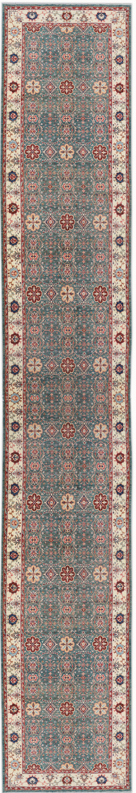 A wide, long runner rug with a traditional design featuring blue, ivory, and red colors.