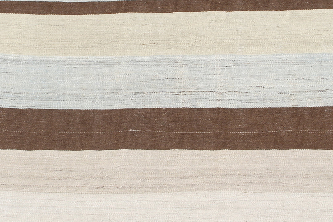 A 5x7 Ariana handmade wool flatweave kilim rug featuring a soft blue and white striped design layout.