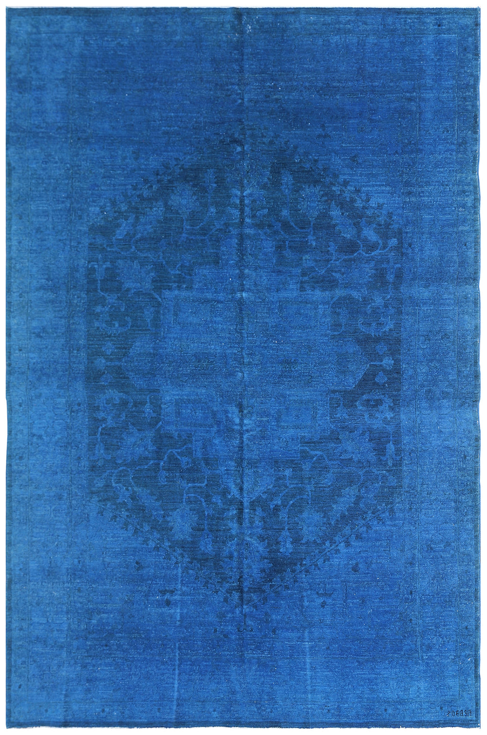 A blue overdye rug with a contemporary Persian design, featuring a geometric pattern in the center surrounded by a solid blue border.