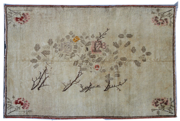 An ivory green rug with a floral pattern and a red border, featuring roses and small branch-like designs.